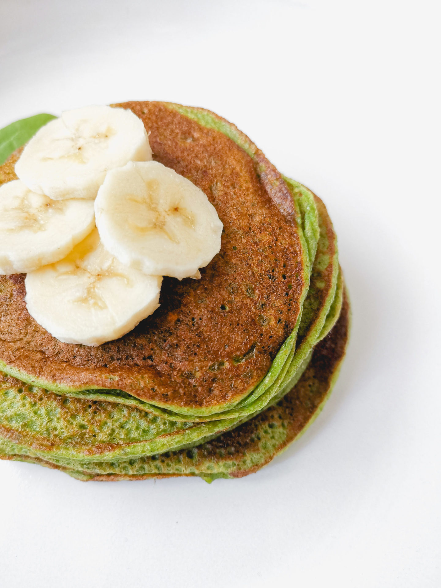 Spinat Bananen Pancakes: Nahaufnahme von einem Haufen Pancakes mit Bananen als Deko