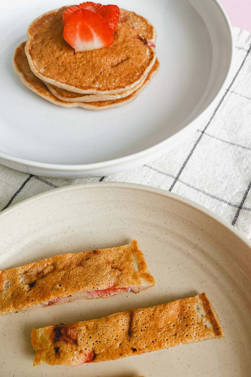 Erdbeeren Bananen Pancakes: Stapel Pancakes mit Erdbeeren als Deko, Pancake Streifen für BLW Baby daneben