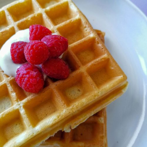 Buttermilch Waffeln: Nahaufnahme Waffeln mit Joghurt und Himbeeren