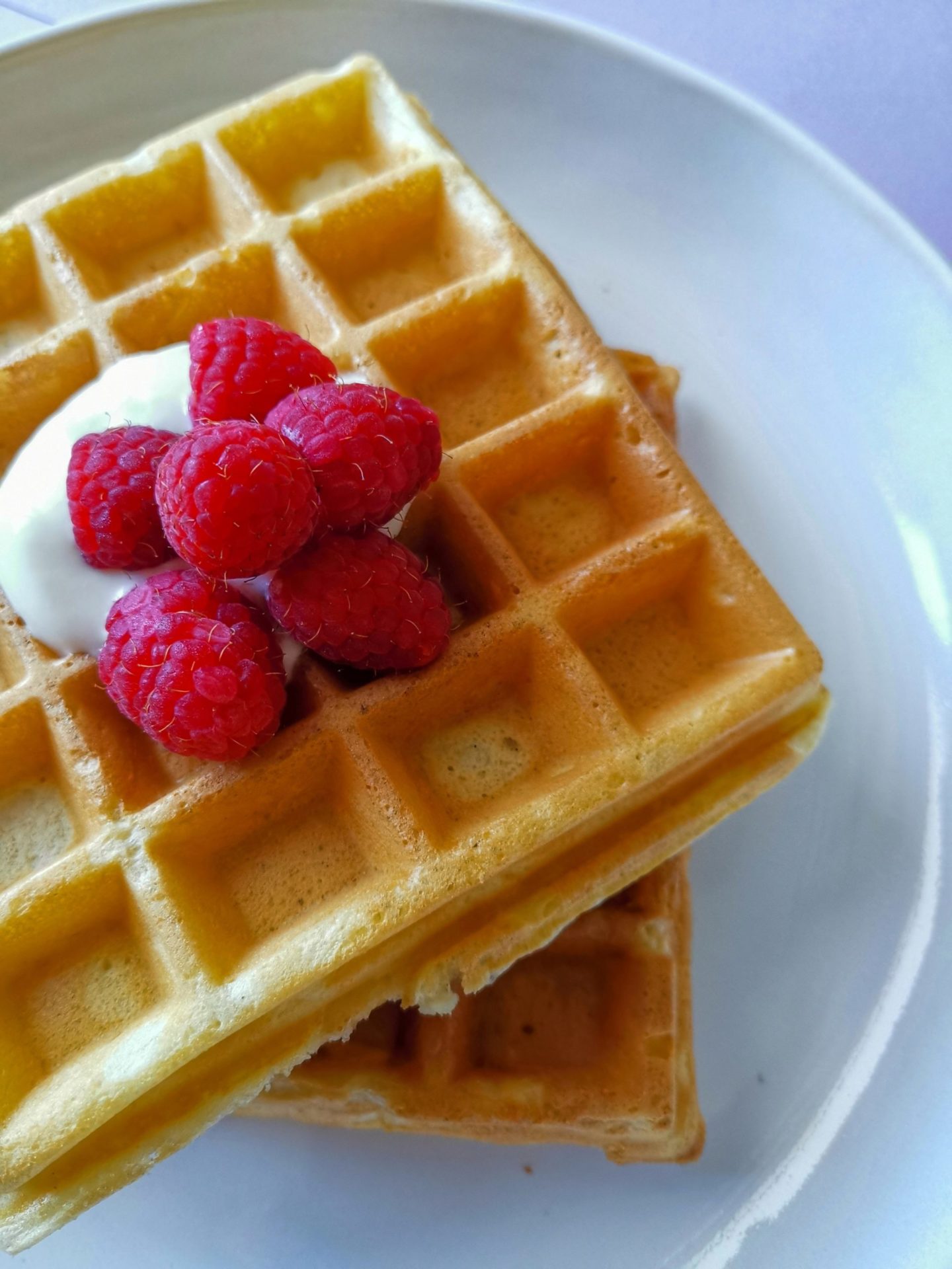 Buttermilch Waffeln: Nahaufnahme Waffeln mit Joghurt und Himbeeren